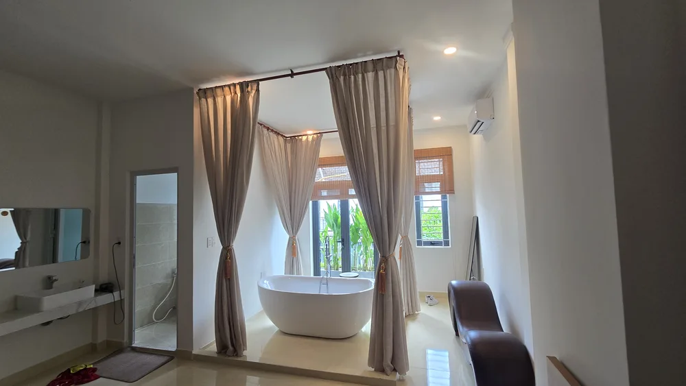 Rèm vải hai lớp màu be quây khu vực bồn tắm nổi trong phòng tắm nhà phố